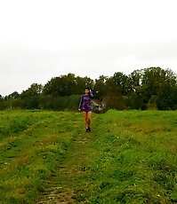 Girl pulls the hem of her dress up to pee outdoors