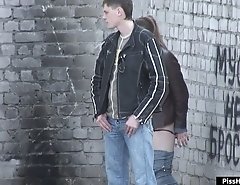 Girl peeing while a guy screens her from glances