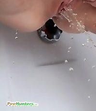 Inked teen makes a golden puddle in the bath tub