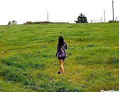 Girl pulls the hem of her dress up to pee outdoors