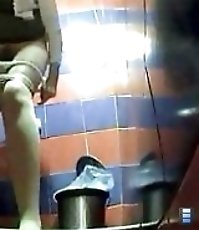 Two babes pissing in a spycammed public toilet