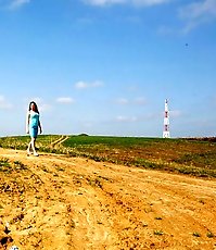 Hot babe in blue dress filmed emptying her bladder